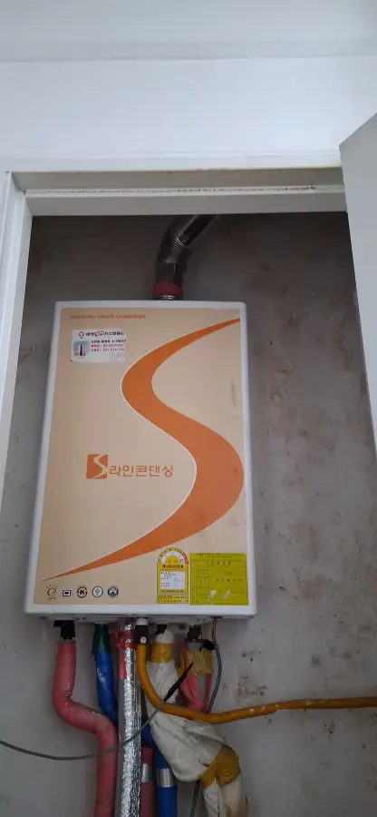 배기 덕트와 계량기가 함께 설치된 보일러실 모습
